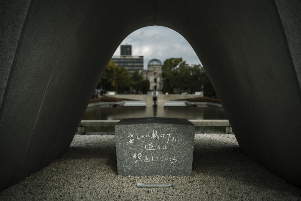 a monument with writing on it and a building in the background