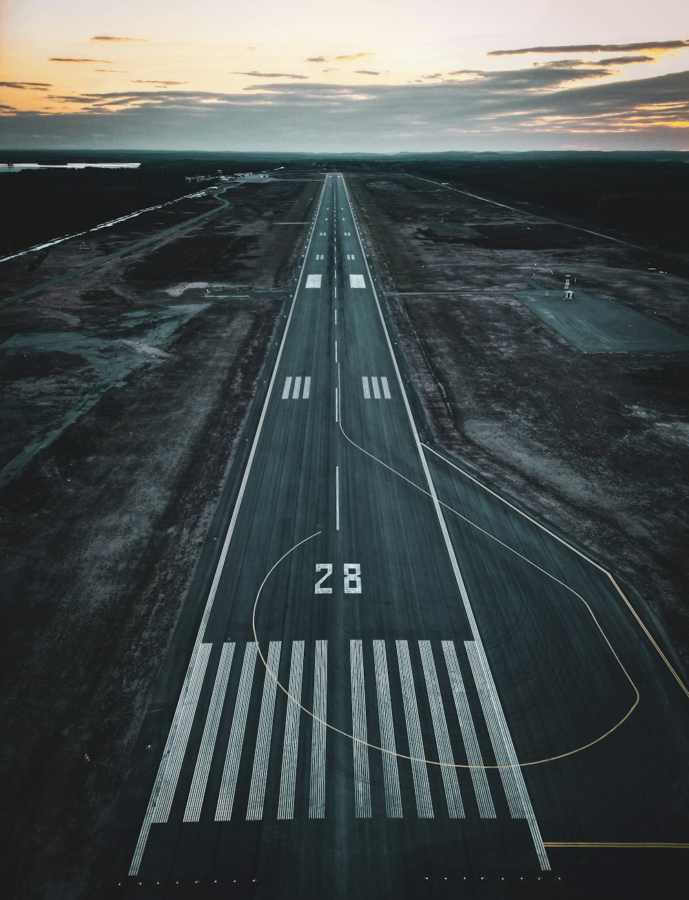 an aerial view of an airport runway at sunset