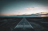 an aerial view of an airport runway at sunset