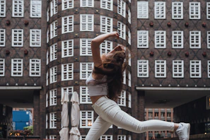 A dynamic street shot capturing a dancer mid-spin with colorful urban graffiti in the background.