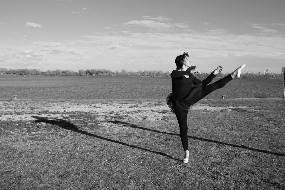 a woman is doing a kick in a field