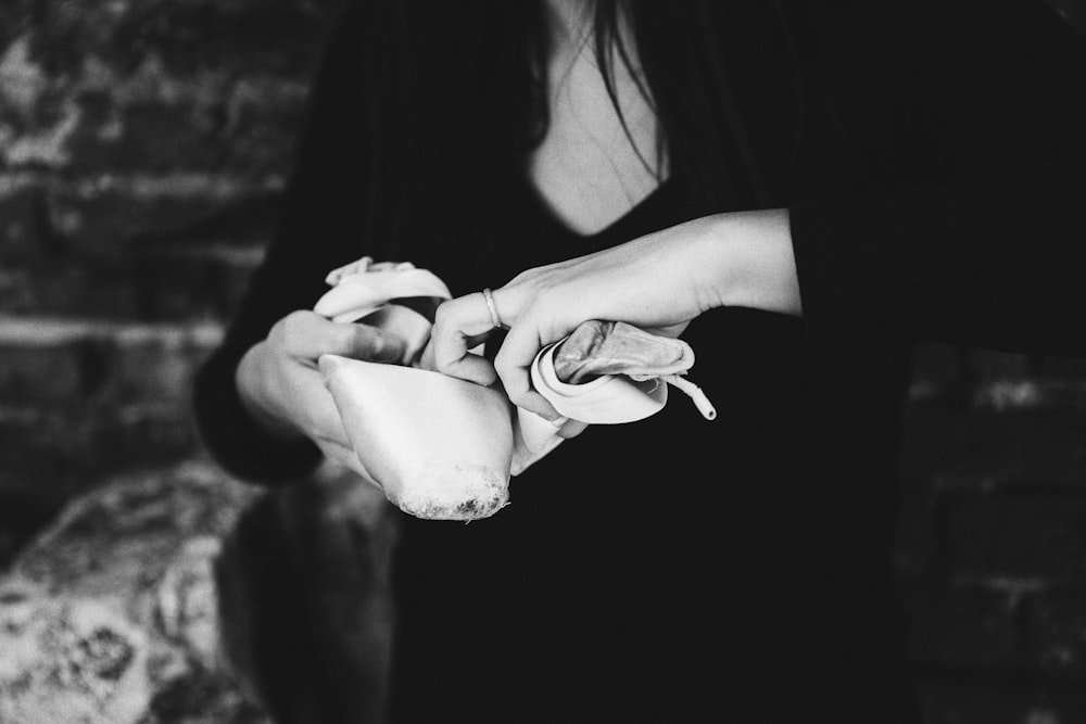 a black and white photo of a woman holding a rose