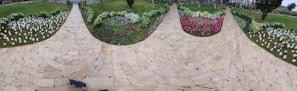 Well-manicured backyard garden with colorful flower beds and a stone pathway