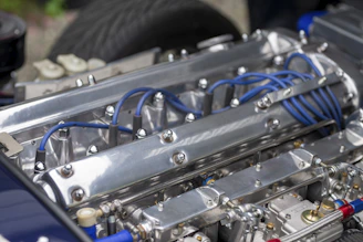 Close-up of a sleek hydrogen engine prototype glowing with electric blue light against a dark background.