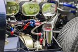 Technician inspecting a large truck engine with spare parts in the background.