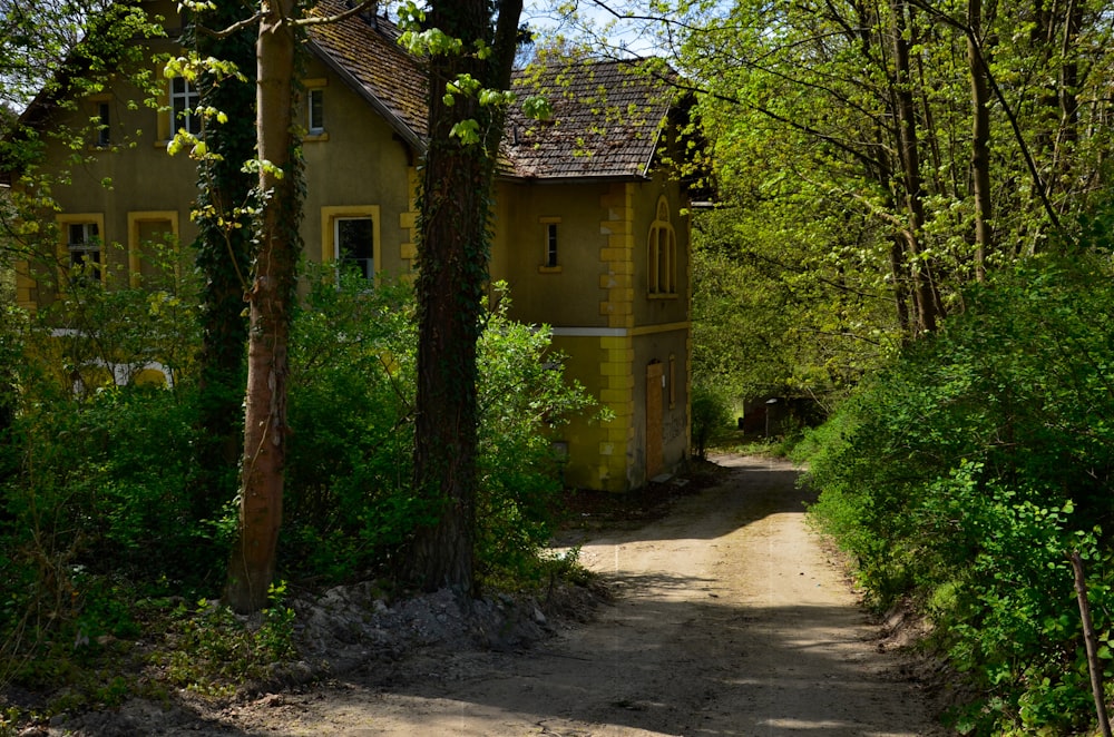 a yellow house in the middle of a wooded area