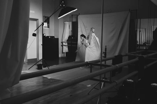 A young dancer practicing a graceful ballet pose in a sunlit studio.