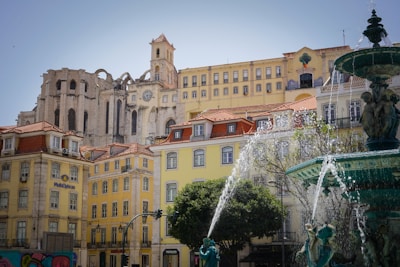 a fountain in front of a row of buildings