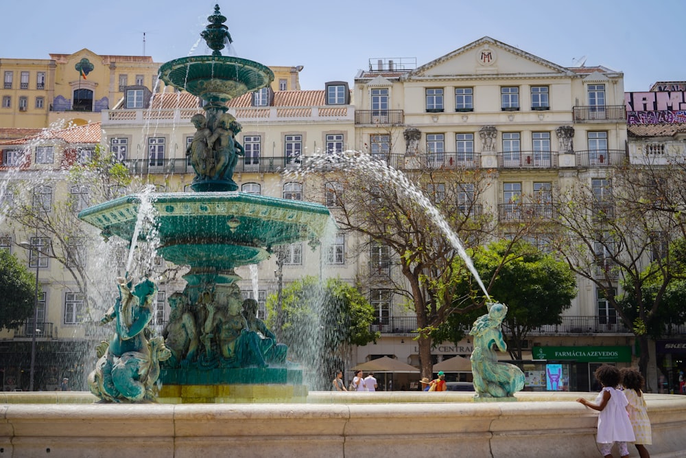 Una niña parada frente a una fuente de agua