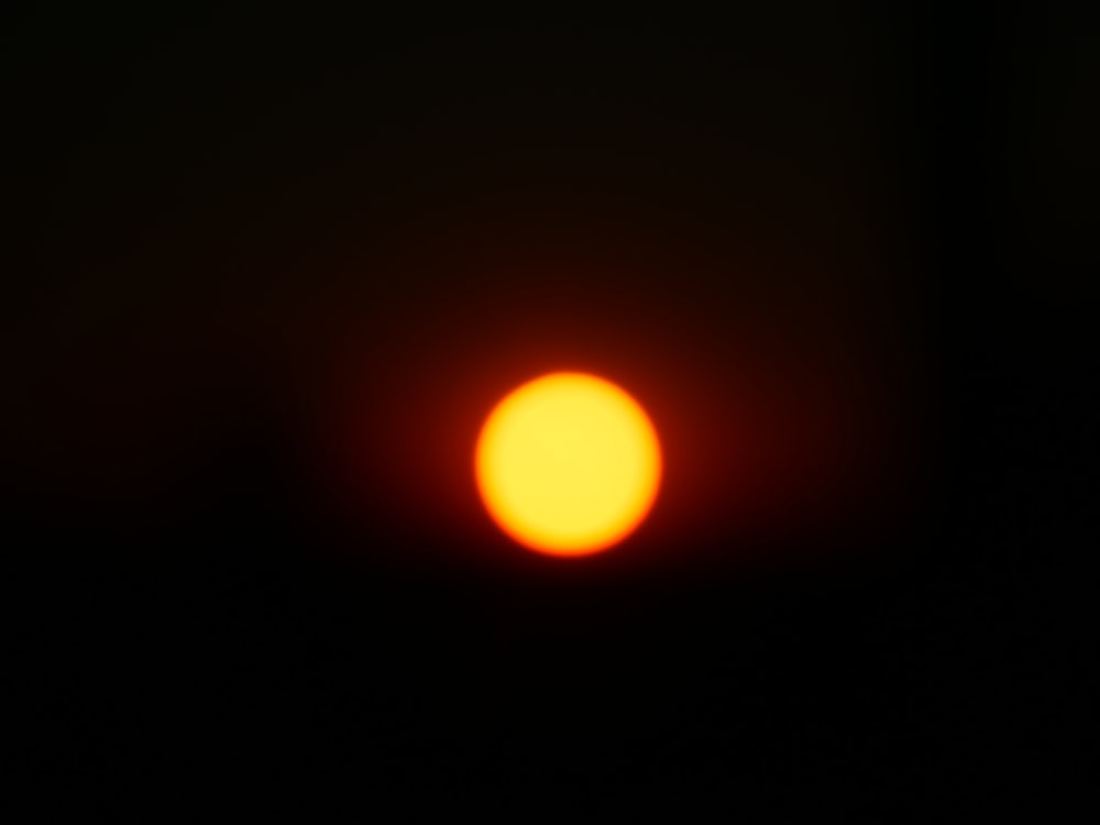 a bright orange ball of light in the dark sky