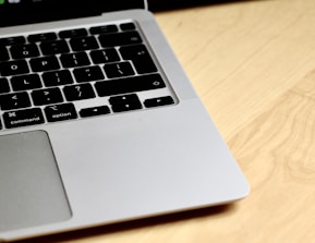 Close-up of hands working on a sleek black laptop with golden accents.
