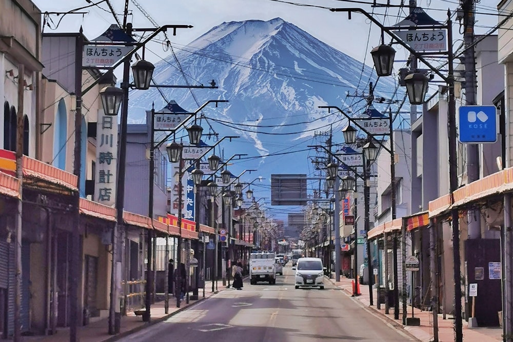 a car driving down a street with a mountain in the background