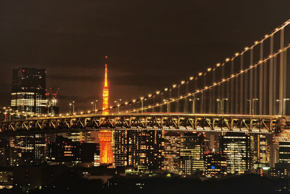 a view of a city at night with a bridge in the foreground