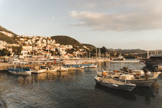 A peaceful seaside town in Spain with boats anchored gently in the harbor under a clear sky.