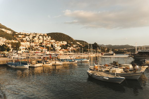 A group of boats floating on top of a body of water — Assos, Turkey