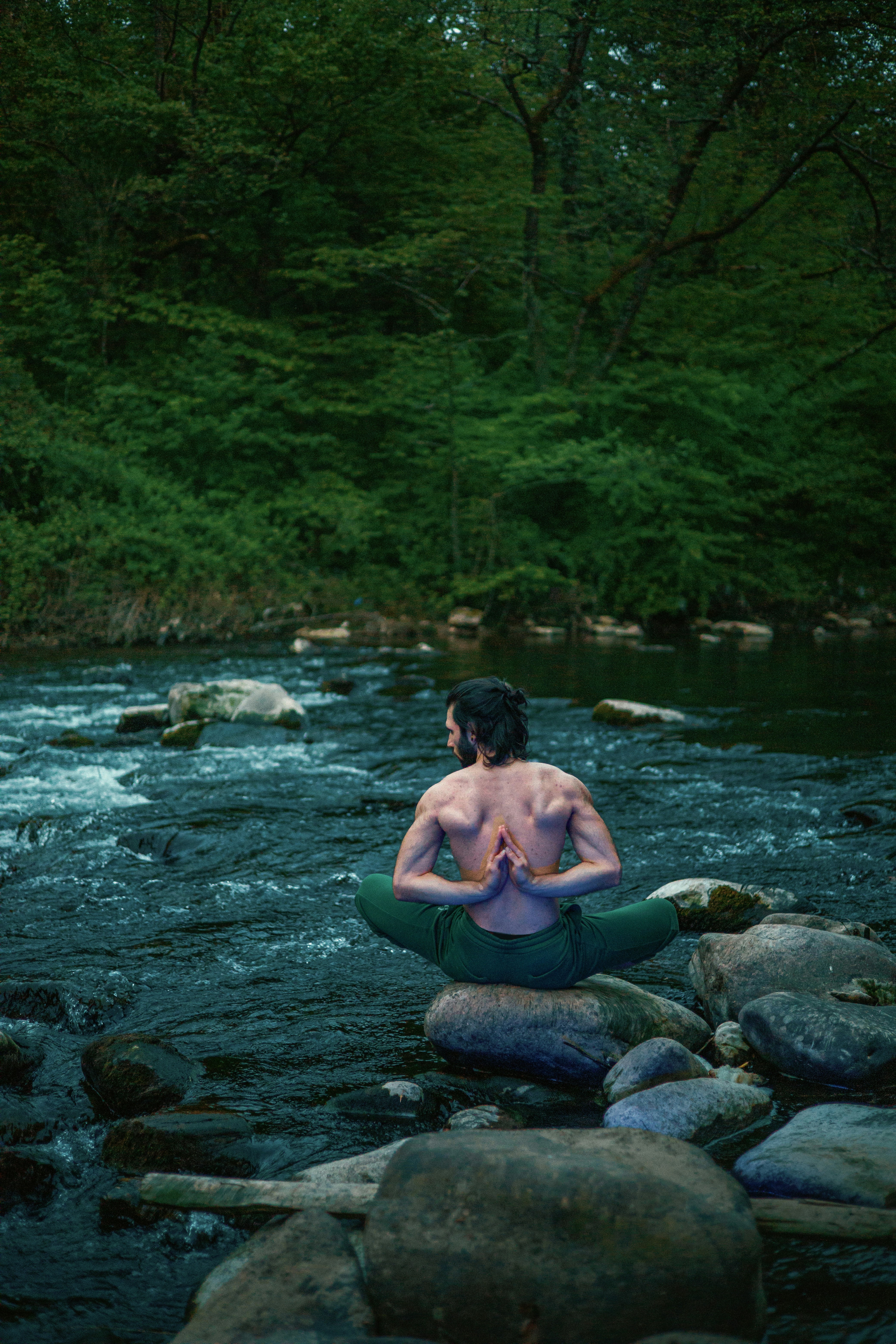 Shirtless man on a raft in a river