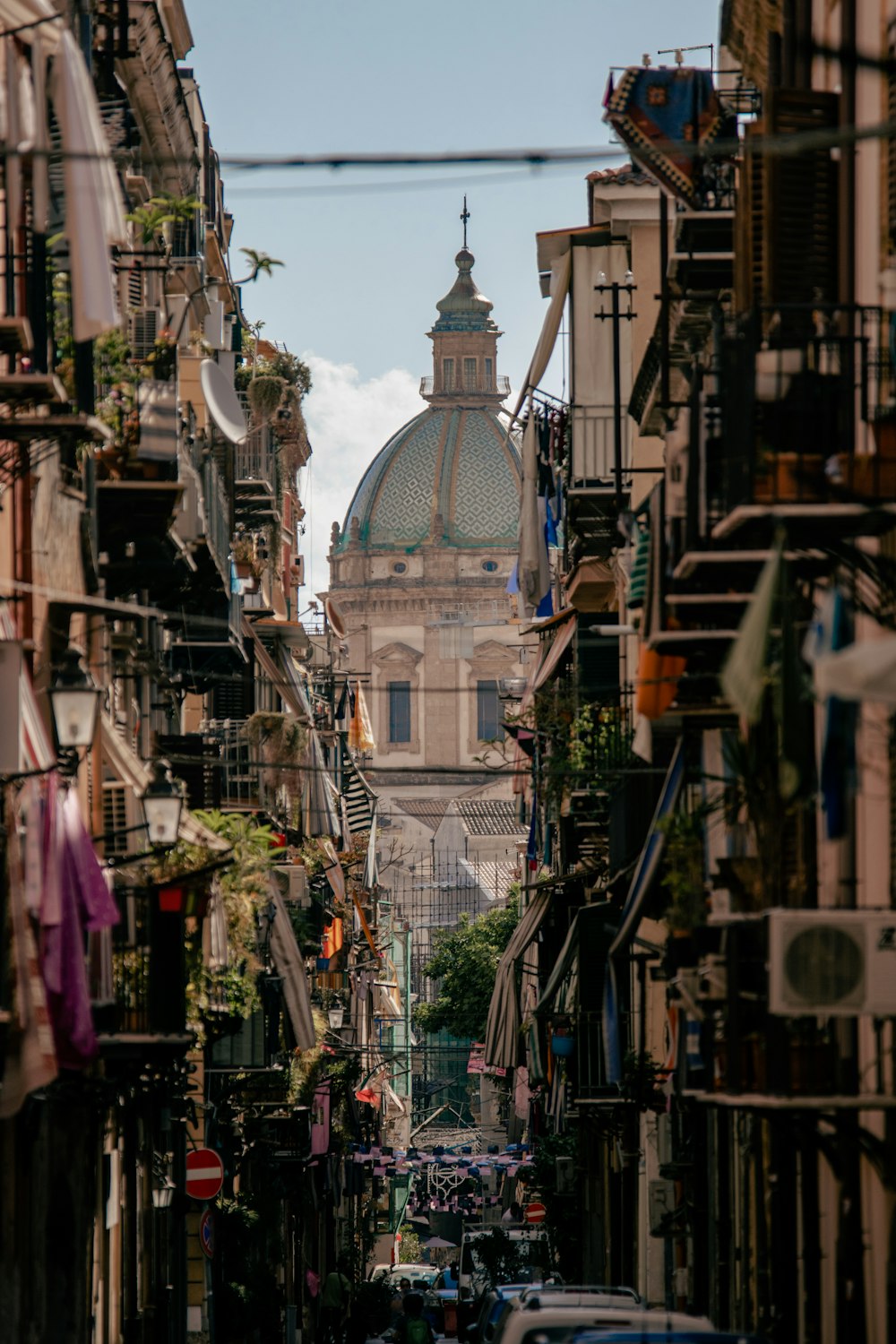 a narrow city street with a church in the background