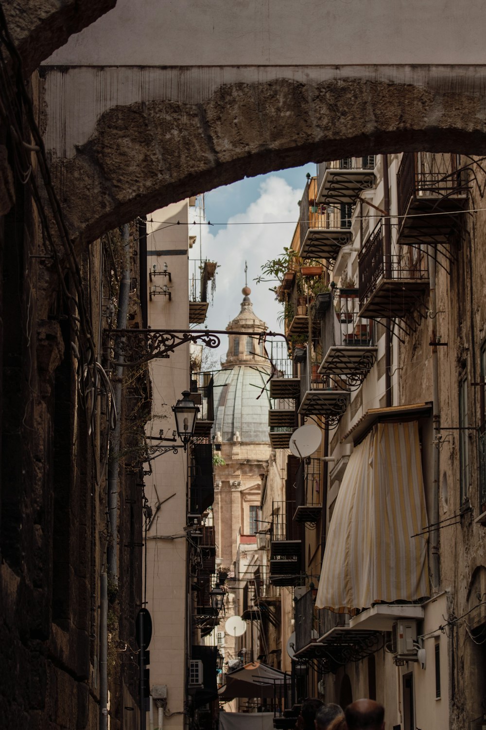 Un vicolo stretto con una torre dell'orologio sullo sfondo