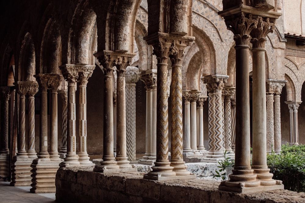 a row of stone pillars next to a building