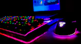 A dynamic angle of a gaming laptop with RGB keyboard lighting pulsating in a dim room.