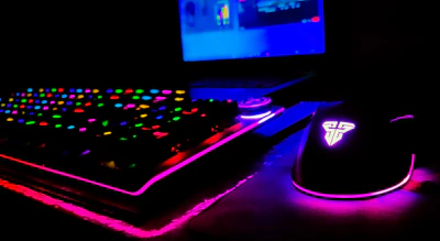 Close-up of a gamer’s hands on a keyboard with colorful RGB lighting.