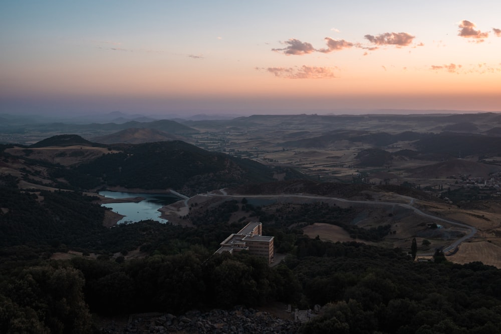 the sun is setting over the hills and lakes