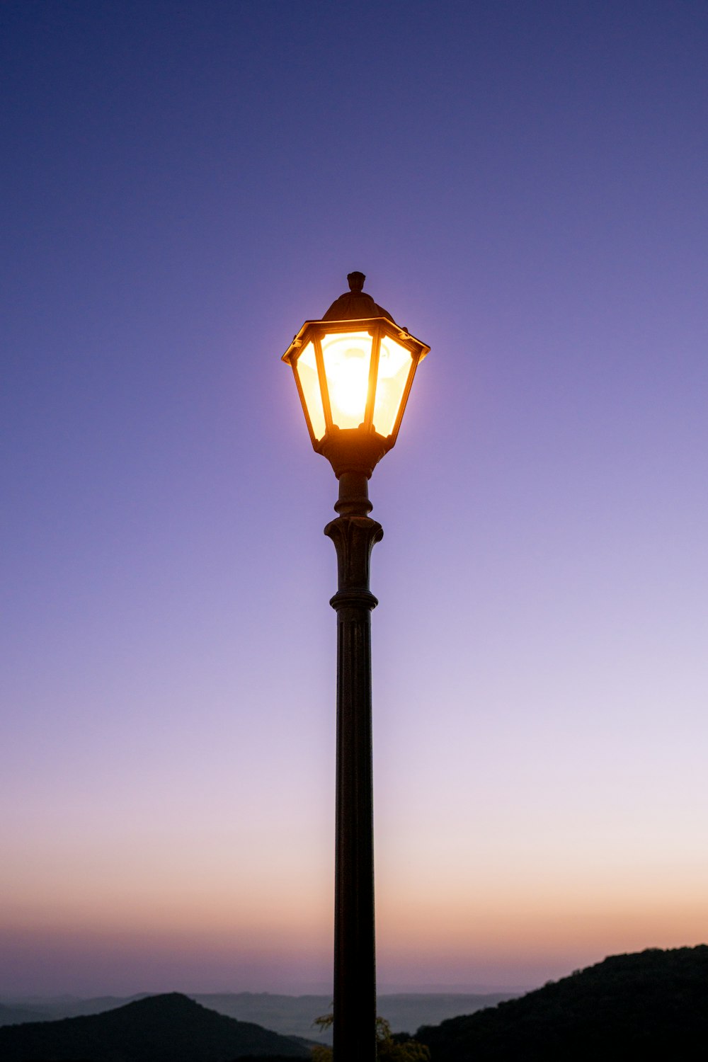 a street light with a purple sky in the background