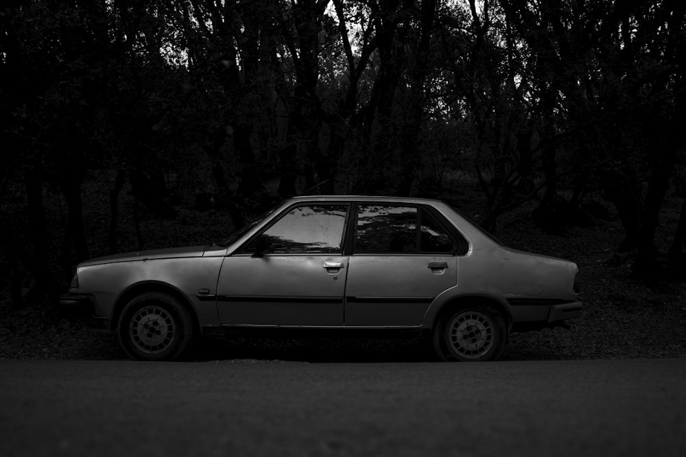a black and white photo of a car parked on the side of the road