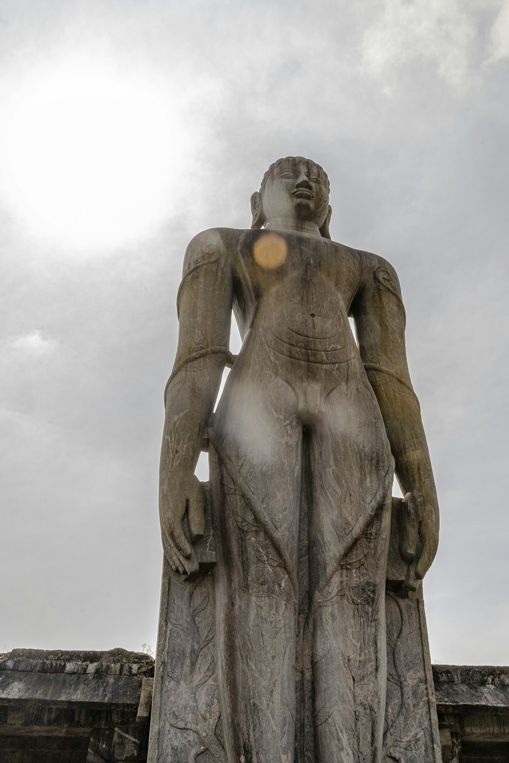 a statue of a man with his hands behind his head