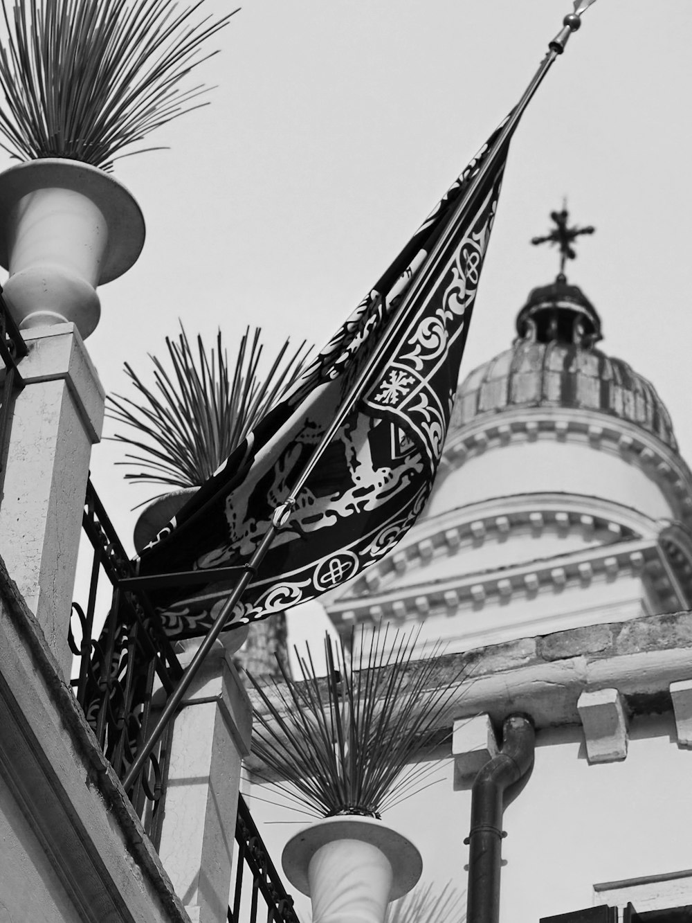 a black and white photo of a building with a flag