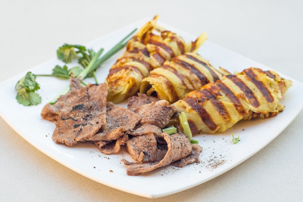 a white plate topped with meat and vegetables