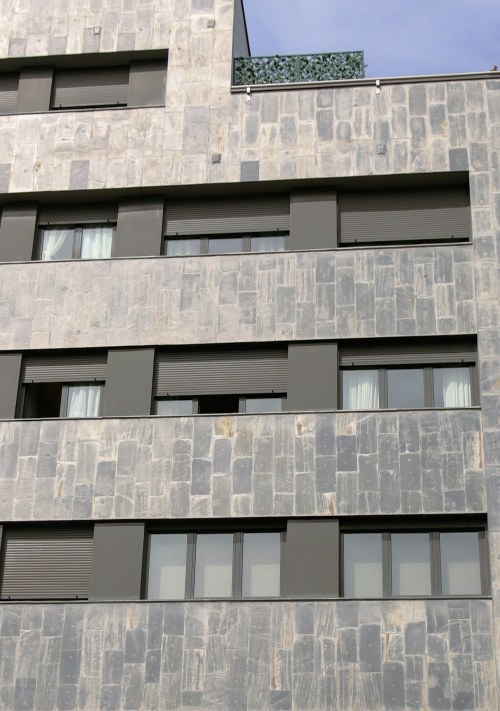 a tall building with many windows and a sky background