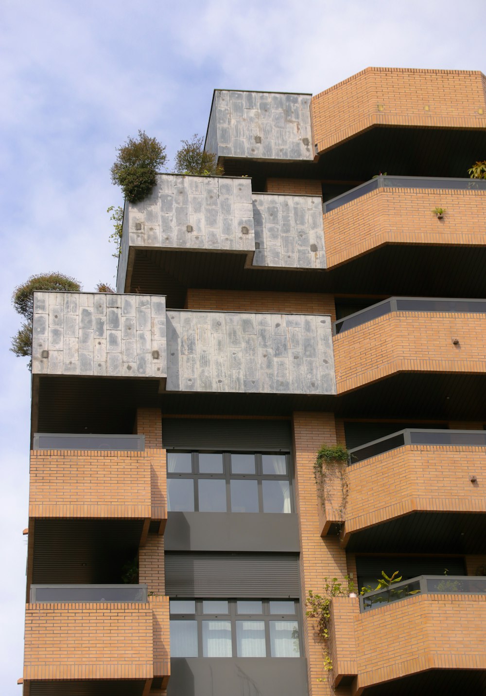 a tall building with balconies and plants on the balconies