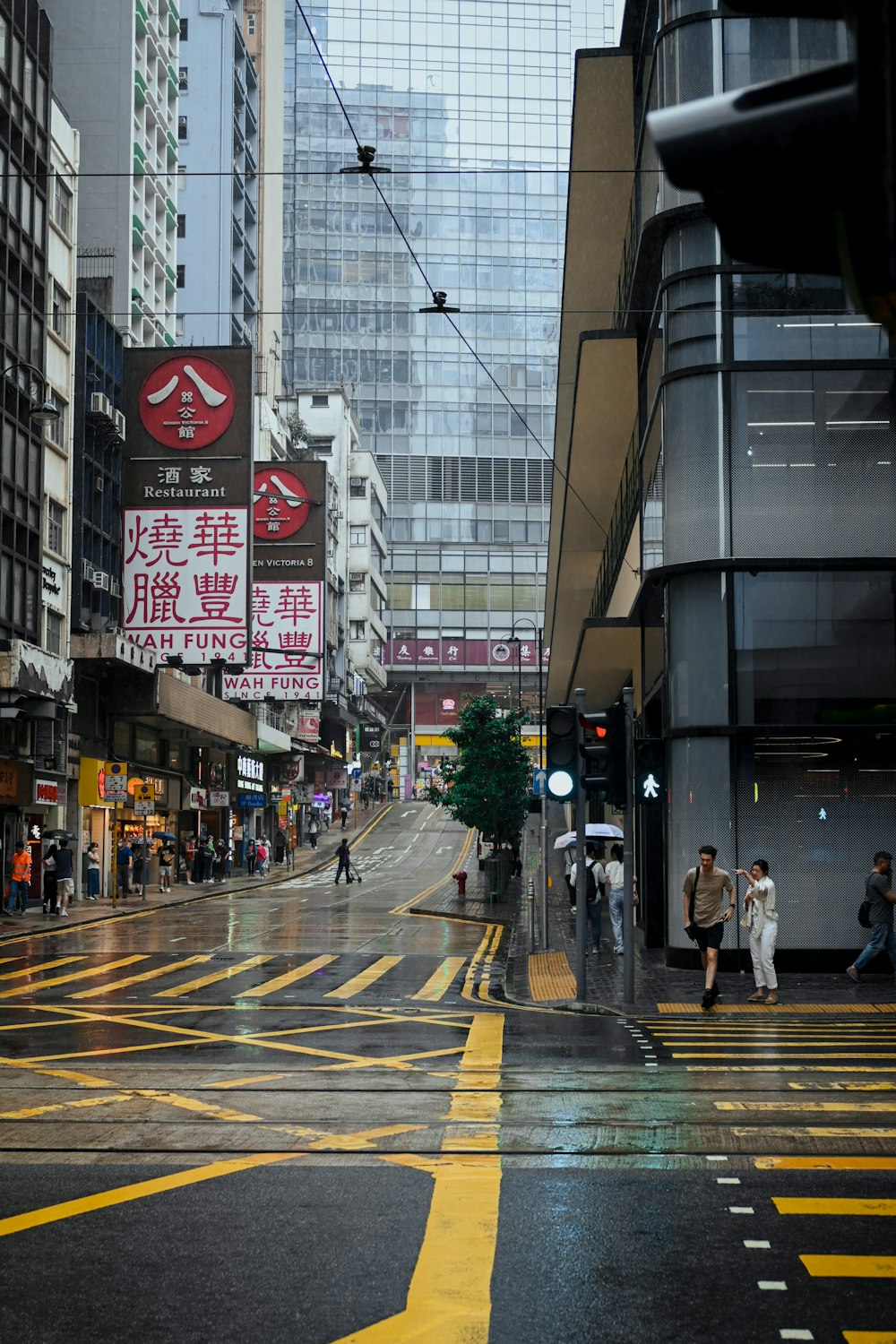 a wet city street with people walking on it