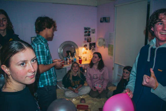 A warm community gathering in a purple-themed room, with people sharing stories and support.