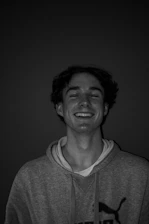 A smiling artist carefully printing a vibrant custom logo on a black hoodie in a bright Kansas studio.