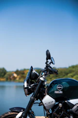 A sleek BRP Skidoo parked beside a crystal-clear lake under a bright blue sky.