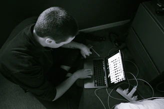 Friendly technician setting up software on a laptop in a cozy home environment.