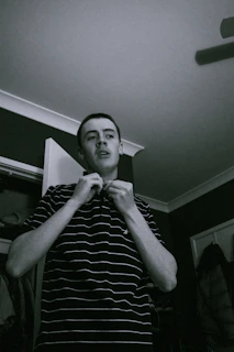 A behind-the-scenes shot of the designer adjusting a conceptual garment in a moody studio.