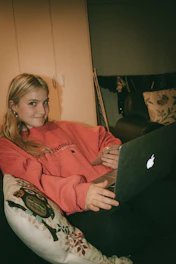 A person exercising with a laptop and smartphone in a cozy home setting.