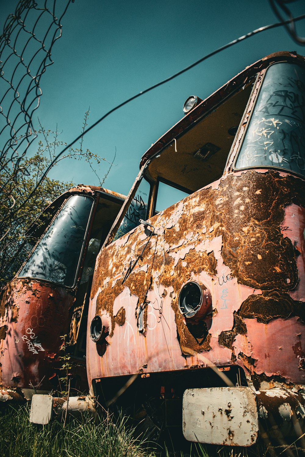 an old rusted out truck sitting in a field