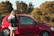 A happy traveler receiving car keys from a rental agent at a sunny outdoor location.