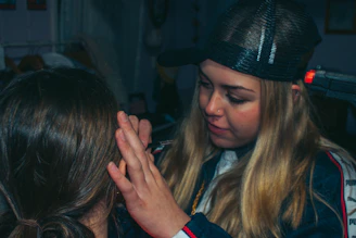 A caring support worker assisting an elderly person with gentle grooming at home.