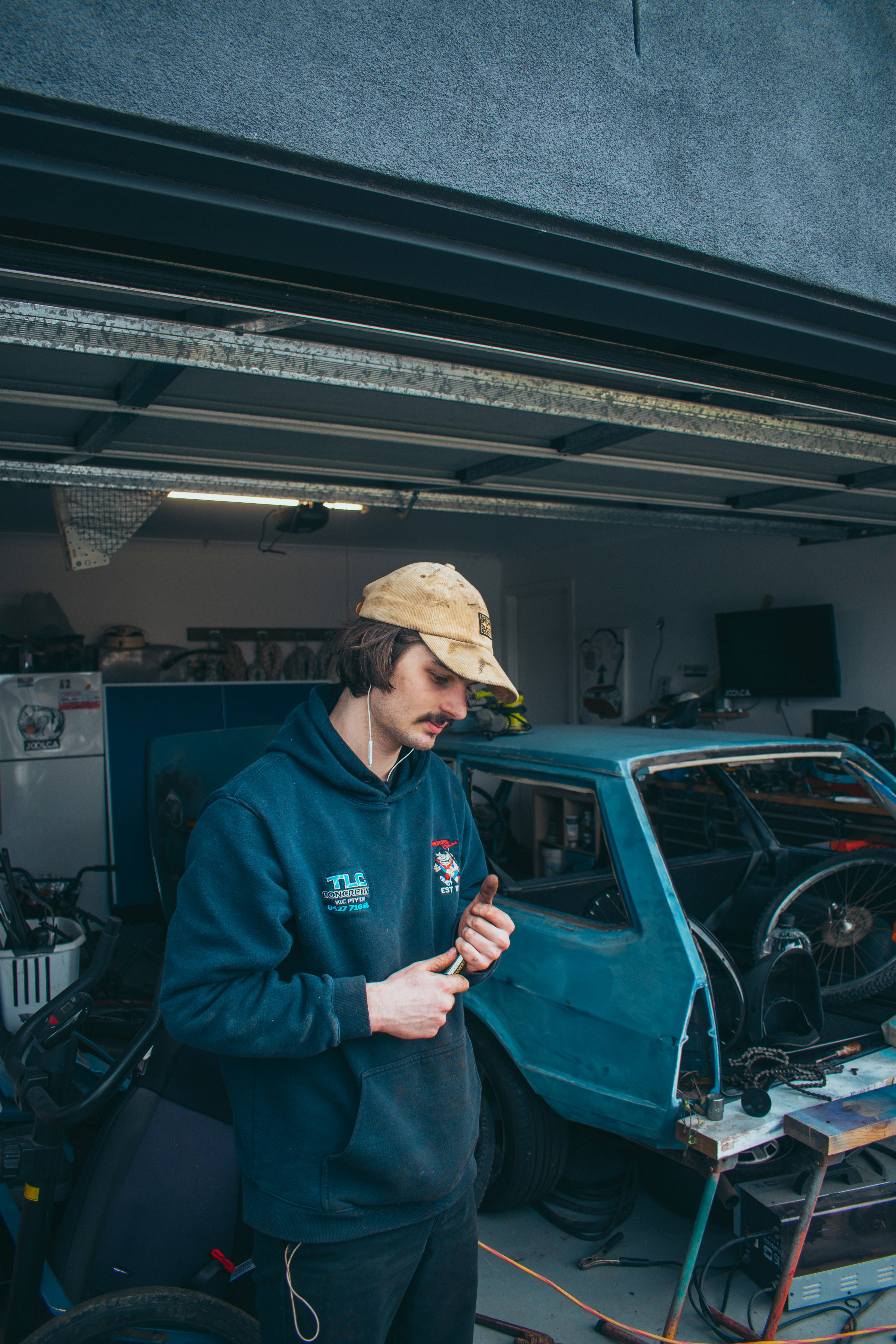 A technician installing a garage door with tools in hand.