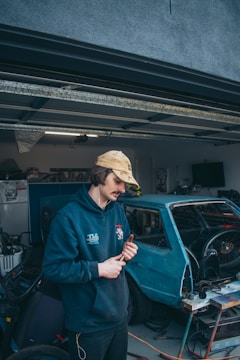 A technician repairing a garage door with tools in hand.