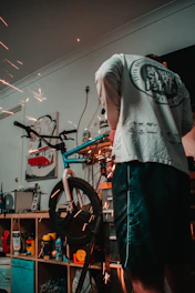 A skilled technician tuning an electric dirt bike in a bright, organized workshop.