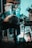 A person is bent over, working on a bicycle in a cluttered garage or workshop. Various tools and storage boxes are scattered around, and there's a stool nearby. Light casts a bluish glow on the scene, highlighting the workspace amid the disorganization.