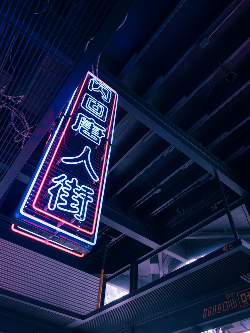 a neon sign hanging from the ceiling of a building