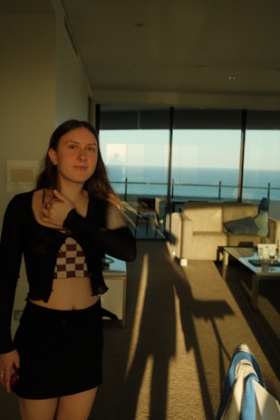 Close-up of a smiling woman standing in a modern, sunlit living room at Godrej Regal Pavilion.
