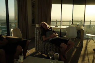 A sleek massage chair in a bright, modern apartment overlooking a bustling cityscape at sunset.